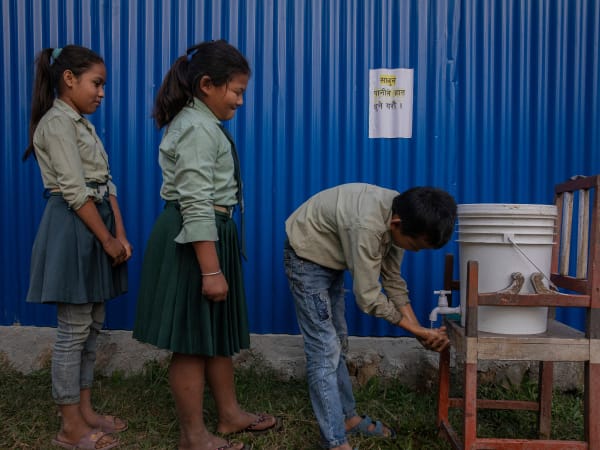 Children queuing to wash their hands at school